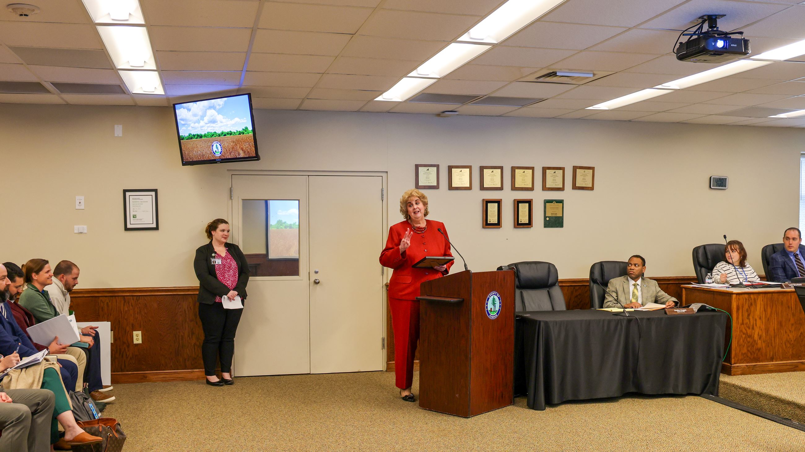 woman in red suit giving speech