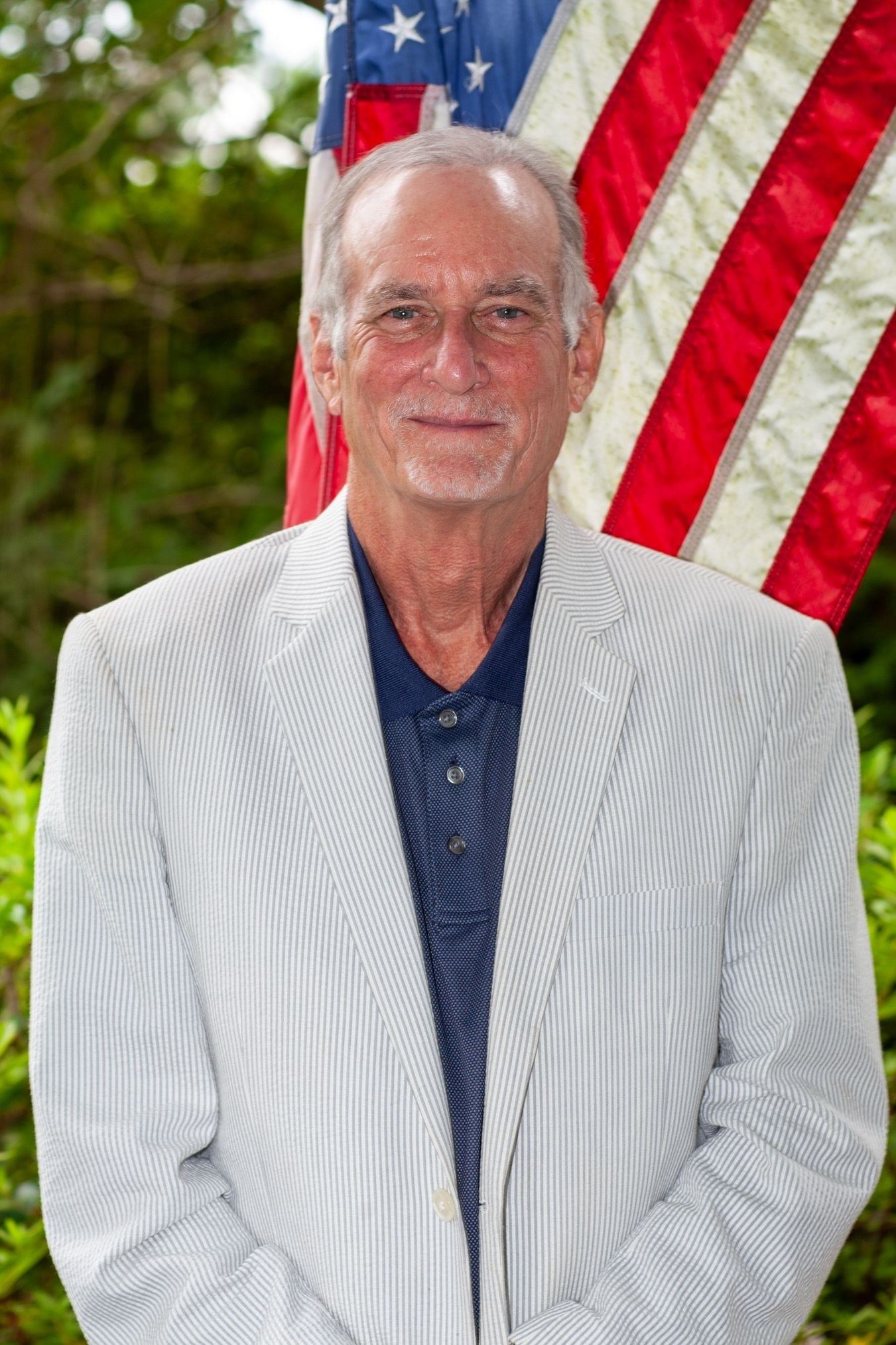 Older man in front of american flag 